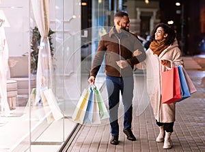 Portrait of happy black couple walking with shopping bags