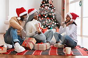Portrait of happy black family celebrating Christmas exchanging presents