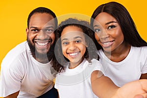Portrait of happy black family taking selfie together at studio