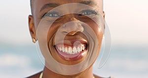 Portrait of a happy black woman standing on the beach during summer for fresh air and to relax. African girl laughing