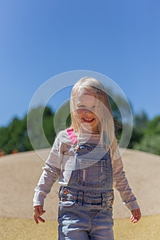 Portrait of happy blonde 4 years girl playing on playground