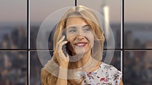 Portrait of a happy blonde woman talking on the phone.