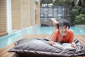 Portrait Happy boy reading a book lying on the bed pillow , education reading concept