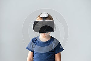 Portrait of happy boy in a virtual reality headset. Attractive kid using vr goggles at home. Entertainment technology