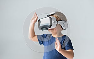 Portrait of happy boy in a virtual reality headset. Attractive kid using vr goggles at home. Entertainment technology