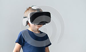 Portrait of happy boy in a virtual reality headset. Attractive kid using vr goggles at home. Entertainment technology