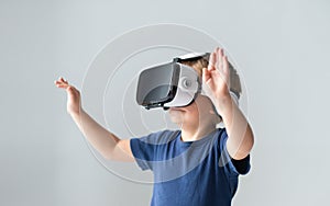 Portrait of happy boy in a virtual reality headset. Attractive kid using vr goggles at home. Entertainment technology