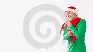 Portrait of happy boy wearing Santa Claus hat and wraps herself in scarf. Child having fun at Christmas time