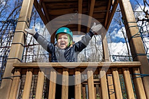 Portrait happy brave courage little toddler child boy wear safety equipment helmet enjoy passing obstacle course forest