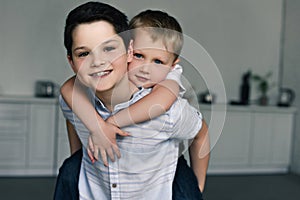 portrait of happy brothers piggybacking together