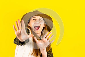 The portrait of a happy brown-haired woman makes a gesture with her fingers, with a surprised expression on her face