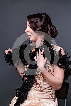 Portrait of happy brunette beautiful woman in boa from ostrich feathers . 20`s years