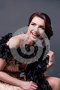 Portrait of happy brunette beautiful woman in boa from ostrich feathers . 20`s years