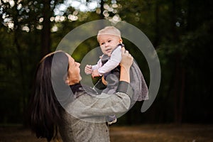 Portrait of happy brunette mother playing with a cute baby daughter