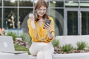 Portrait of happy business caucasian woman enjoy success on mobile phone. Joyful girl reading good news on phone