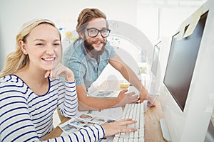 Portrait of happy business people at computer desk