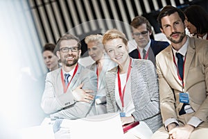 Portrait of happy business people sitting in seminar hall