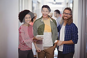 Portrait of happy business people standing together in corridor