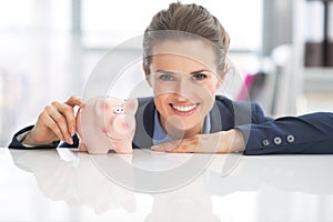 Portrait of happy business woman with piggy bank