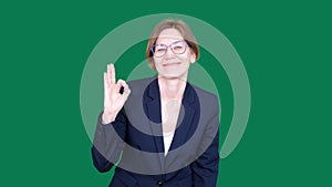 A Portrait Of A Happy Business Woman Showing Okay Gesture To The Camera In The Green Screen Studio