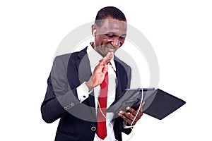 Portrait of a happy businessman communicating using a tablet and headphones