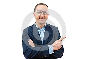 Portrait of a happy businessman in glasses pointing his finger to the side on a white background. Young man in a suit