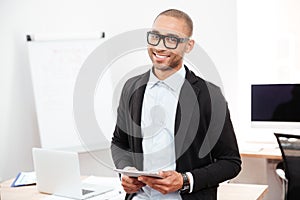 Portrait of a happy businessman holding pc tablet