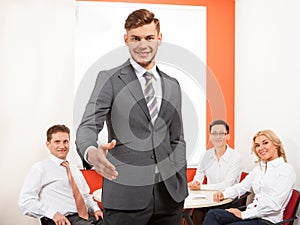 Portrait of happy businessman offering handshake and his team.