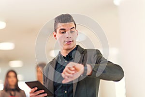 Portrait of happy businessman in office holding digital tablet