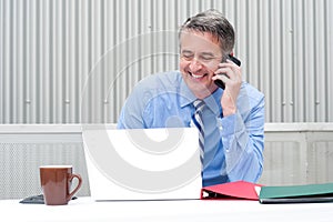 Portrait of a happy businessman on phone