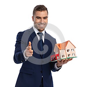 Portrait of happy businessman recommending building model photo