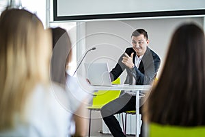 Portrait of happy businessman standing in seminar hall. Business meeting