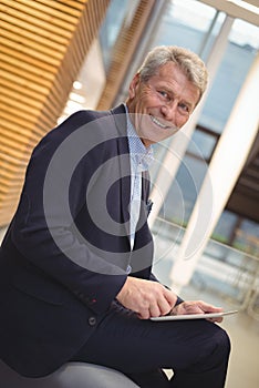 Portrait of happy businessman using digital tablet