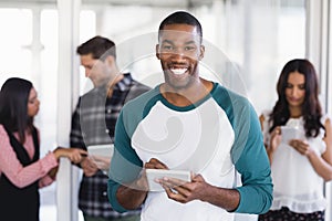 Portrait of happy businessman using digital tablet