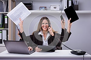 Businesswoman Doing Multitasking Work In Office