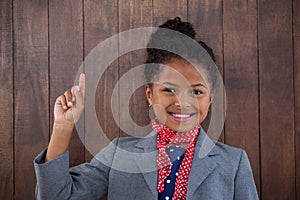 Portrait of happy businesswoman pointing upwards