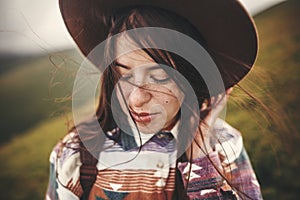 Portrait of happy calm young woman with windy hair. Carefree mood. Amazing atmospheric moment. Stylish hipster girl in hat and