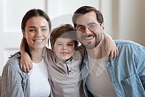 Portrait of happy caring family of three bonding at home.