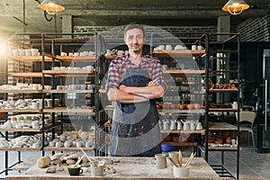 Portrait of happy caucasian creative man as a worker or business owner at the pottery workshop.