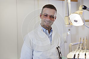 Portrait of happy caucasian dentist smiling at camera