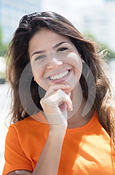 Portrait of a happy caucasian woman in a orange shirt in the cit