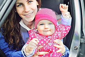 Portrait of happy cheerful family. Laughing faces, mother holding adorable child baby girl, smiling and hugging. Mom and daughter