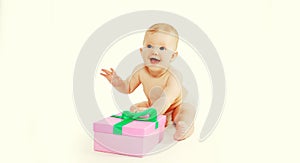 Portrait of happy cheerful laughing baby with gift box sitting on the floor on white background