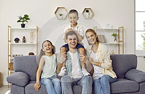 Portrait of happy, cheerful, laughing family sitting together on the sofa at home