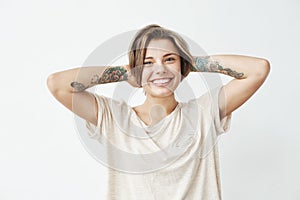 Portrait of happy cheerful pretty tattooed girl smiling looking at camera over white background.