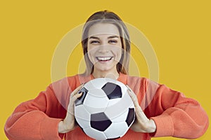 Portrait of a happy cheerful young student girl holding a soccer ball and smiling