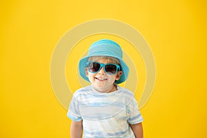 Portrait of happy child against yellow background. Summer vacation concept