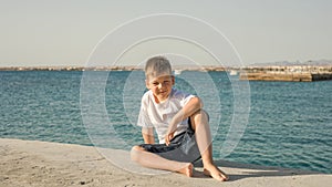Portrait of happy child on the beach. Summer vacation concept. Smiling kid boy  near sea