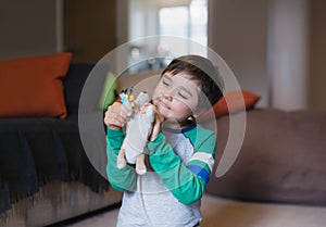 Portrait happy Child boy playing with dog toy in living room, Positive young kid having fun playing with his toys relaxing at home