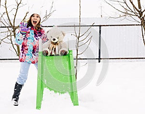Portrait of happy child girl playing with teddy on a winter walk in nature. Outdoor fun for winter vacation. Baby